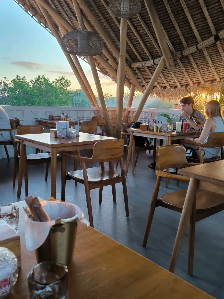 open-air dining area with seating and greenery